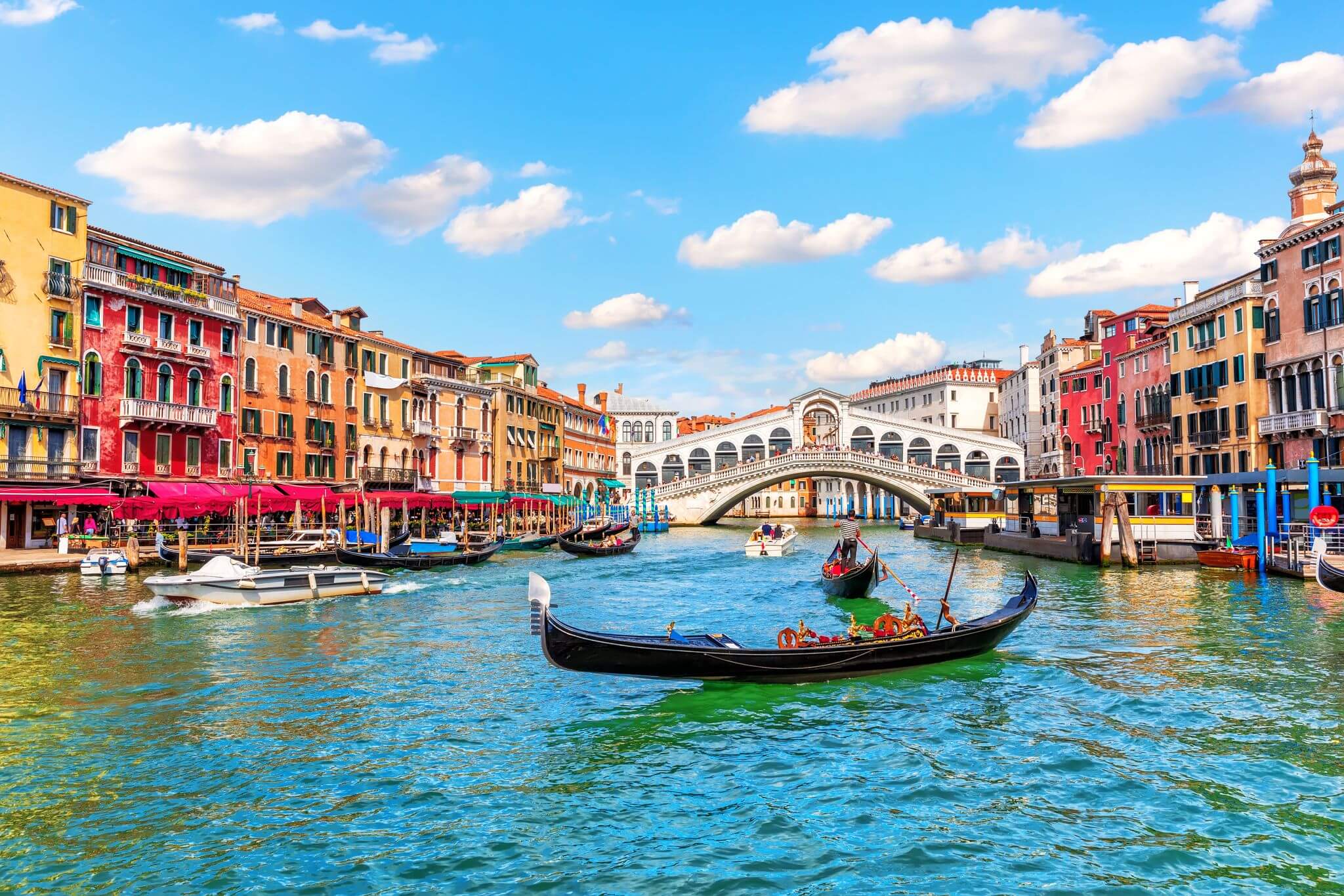 Gondolas along the river in Venice, surrounded by vibrantly colourful buildings