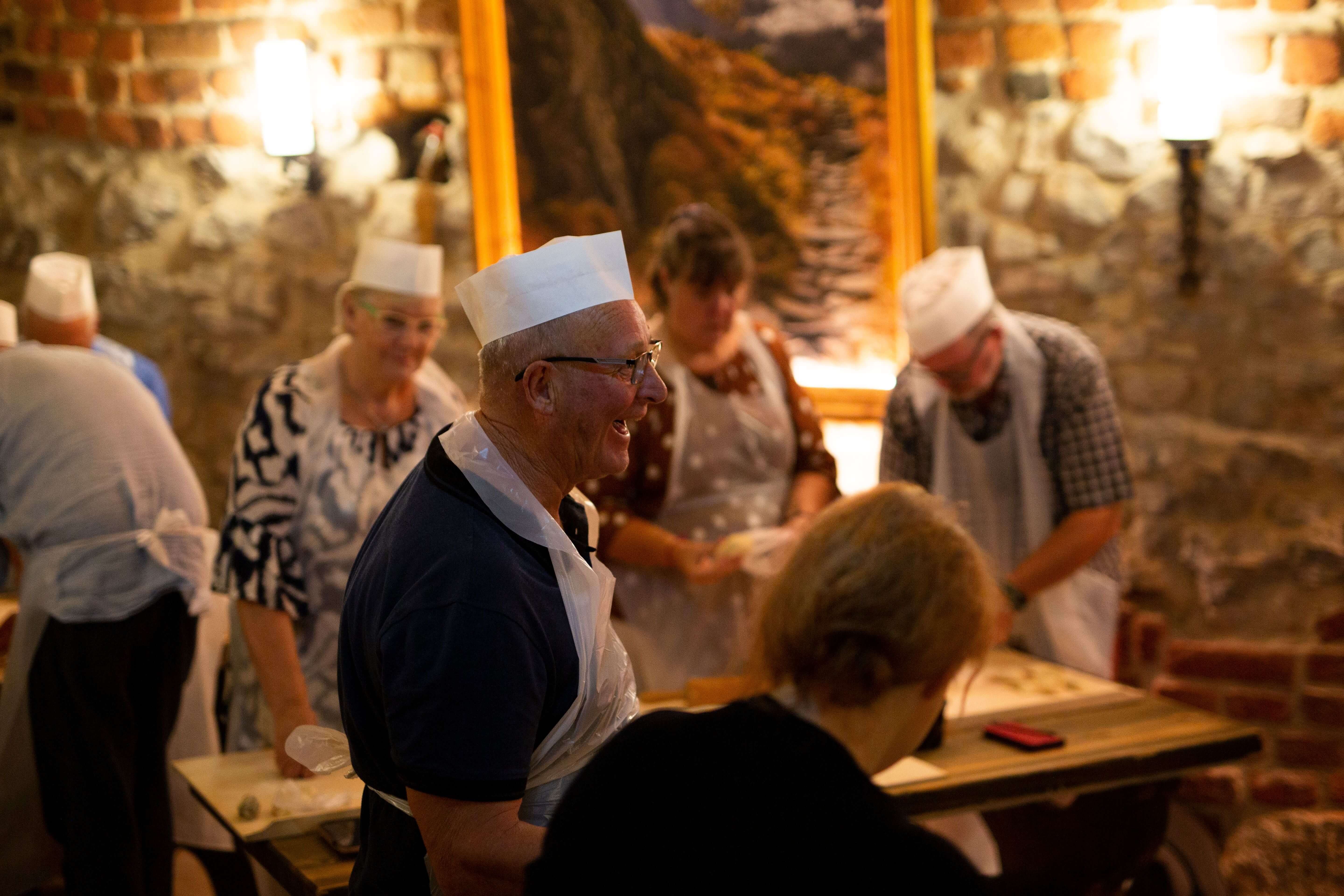 Mature man smiling during pierogi cooking in Kraków