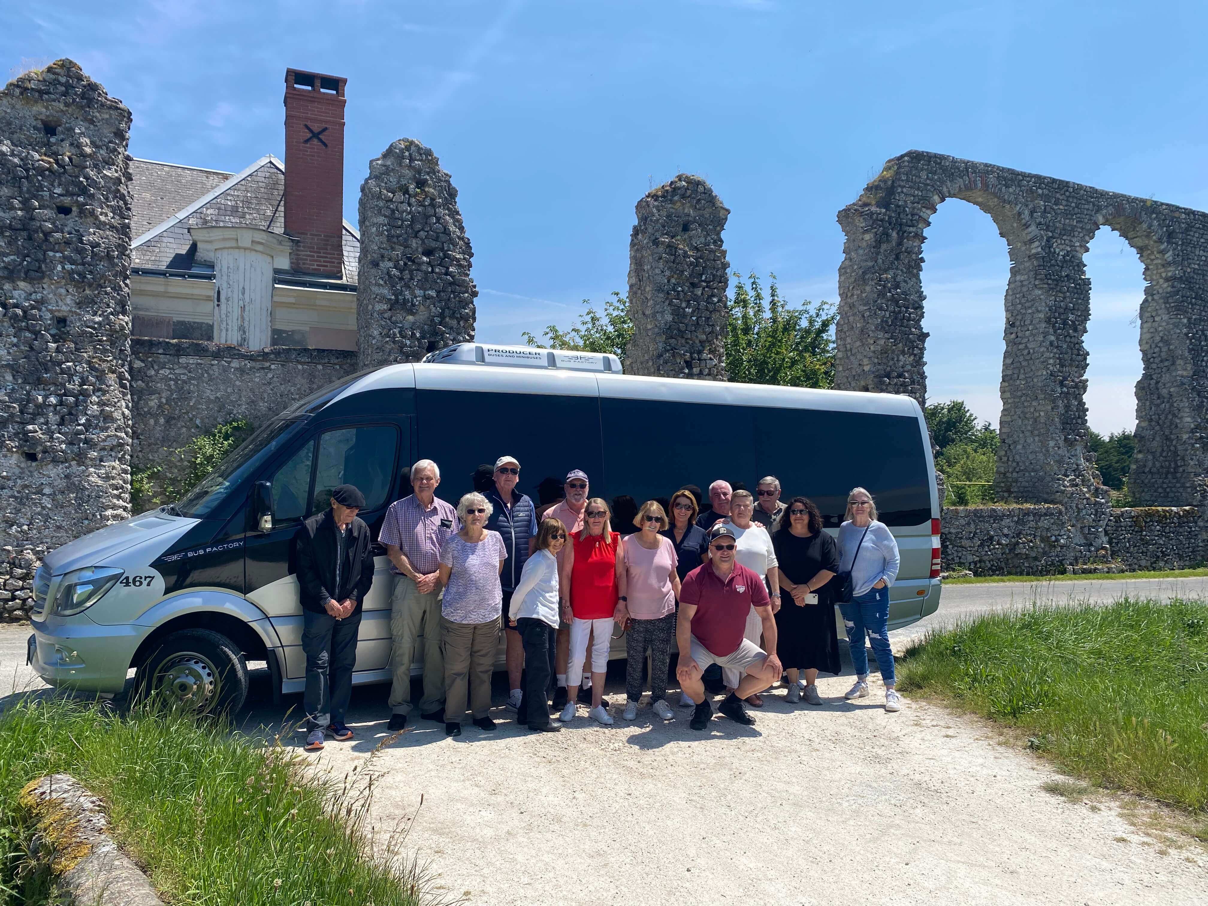 Group of travellers posing in front of bus in France