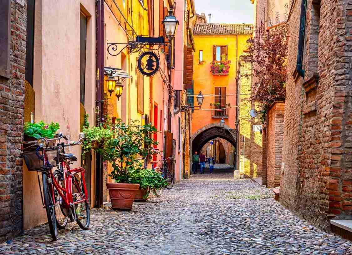 Narrow Italian street with yellow buildings and a cobbled pathway