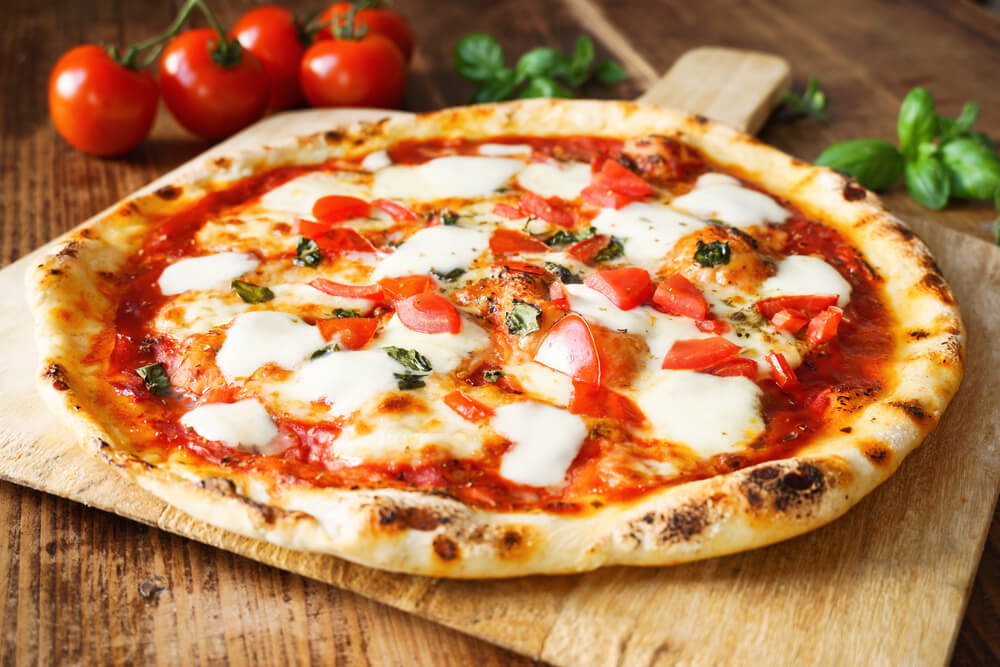 close up of pizza on a wooden serving board