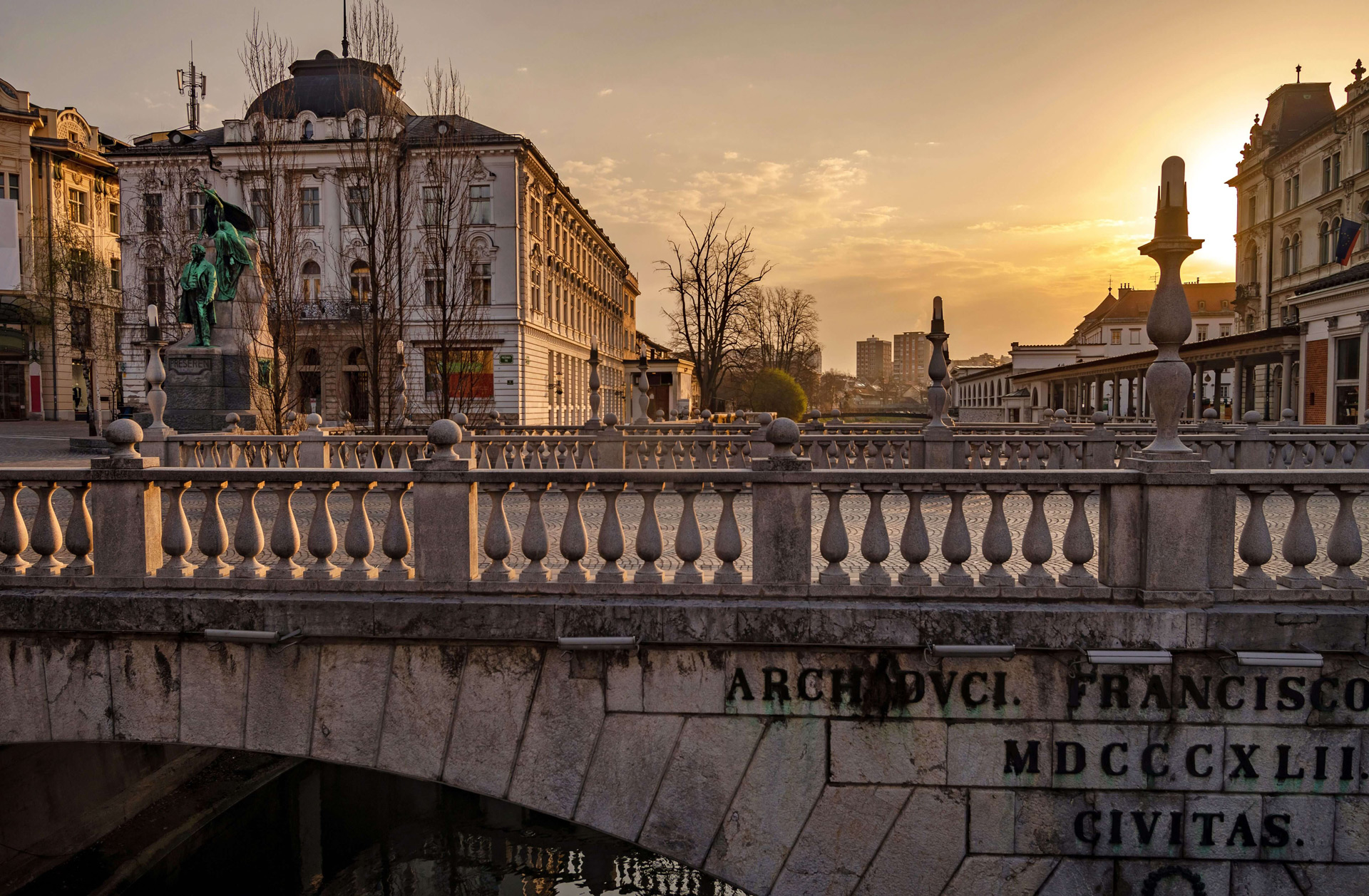 A view of an old Bridge cutting through the old town of Slovenia's capital of Ljubljana, just as the sun sets.