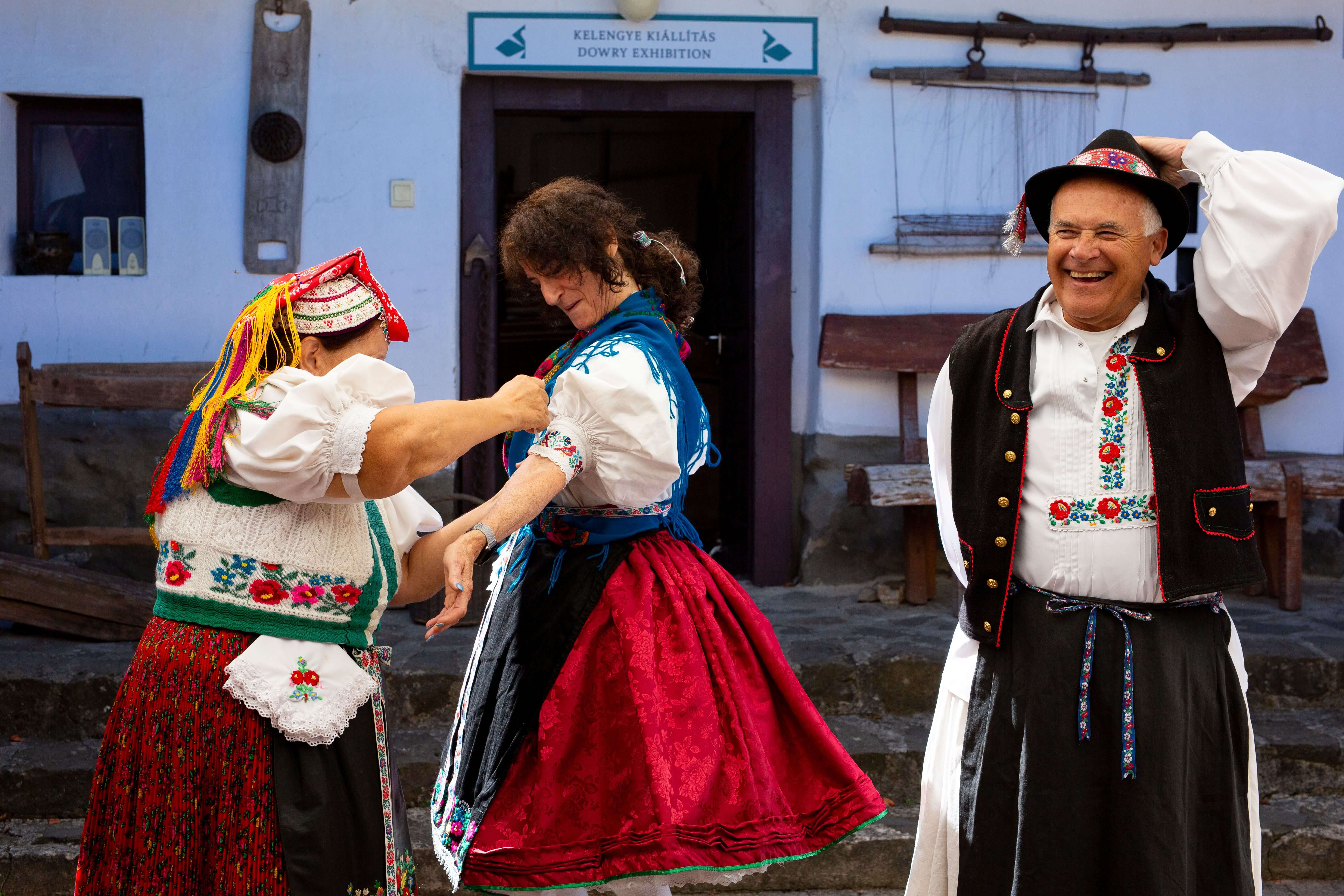 Two women and one man dressed in traditional Hungarian clothing