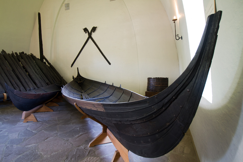 a pair of Viking era ships in the Viking Ship Museum, Oslo