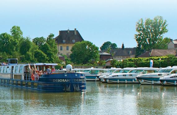 A river cruise boat travels down the Rhone-Rhine Canal in Loire Valley.