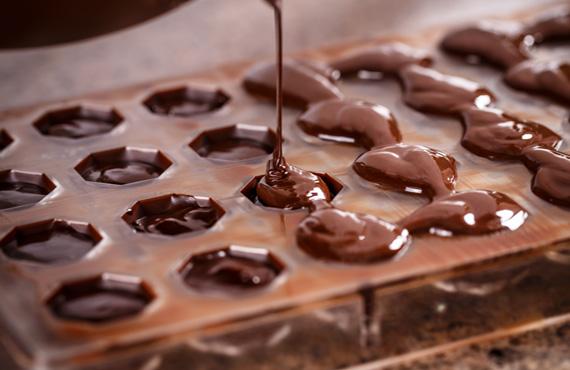 Handmade Swiss chocolate being poured into specialty trays.