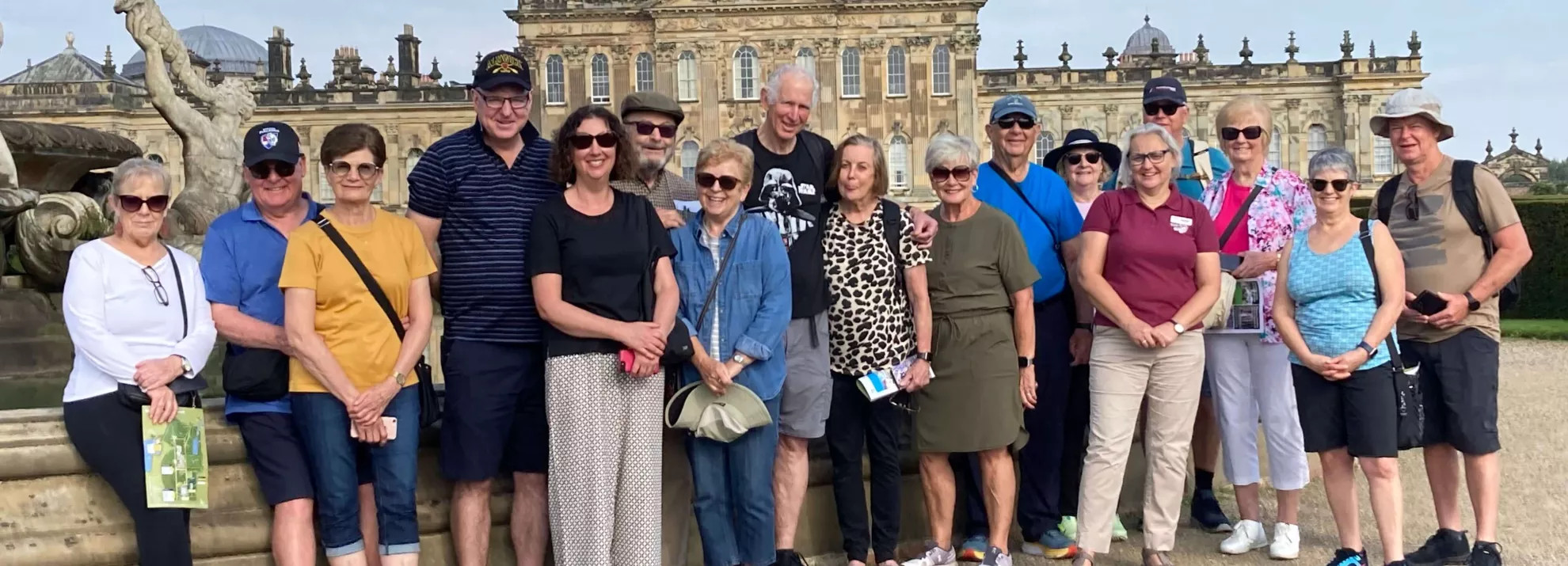 Group of mature adults standing together in front of British monument