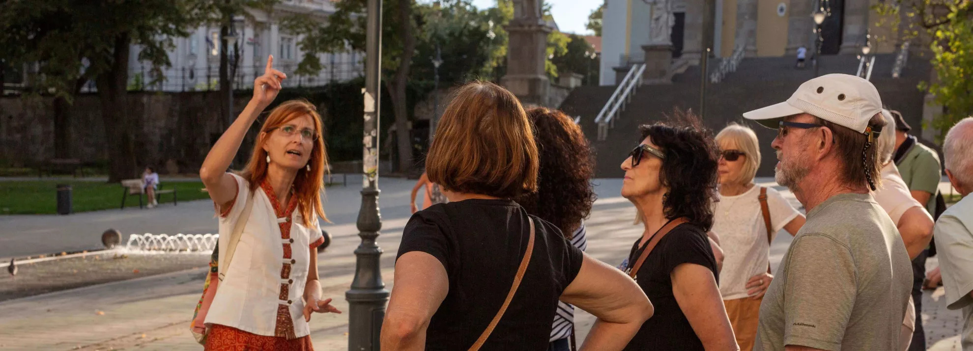 Female Tour Leader pointing out a building to a small group during orientation walk