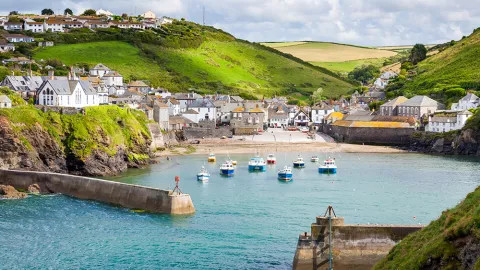 A view of the idyllic Cornish town of Port Isaac, with small boats moored on the waterfront.