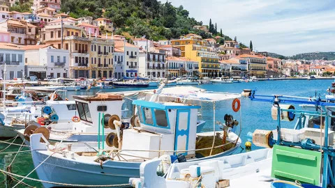 Boats and small vessels line the waterfront of Gytheio, adorned with colourful lively houses.
