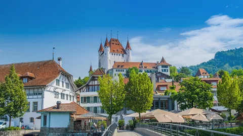 A landscape view of the grand Thun Castle, situated on Lake Thun.