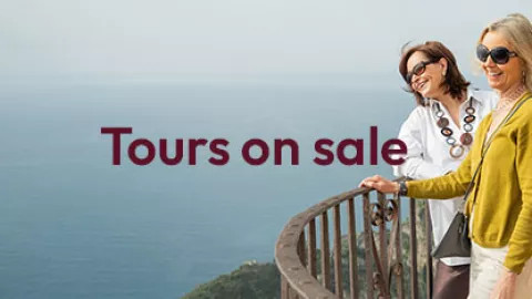 Two women admiring the sea view, with text overlay of tours on sale