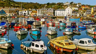 Small colorful boats moored in Cornwall harbor.