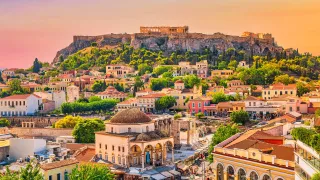 A view over Athens at dusk with the famous Acropolis looming in the background.