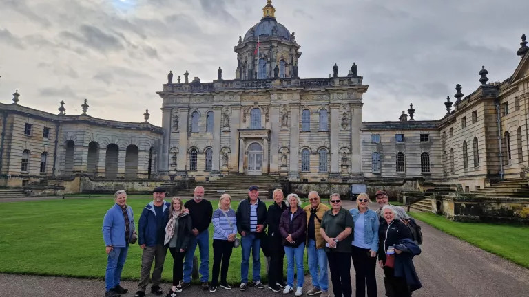 Group standing in front of grand house
