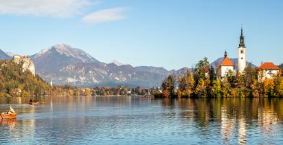 A view of Lake Bled in North-western Slovenia, with a couple rowing in the foreground.