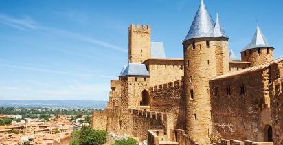 The iconic fortress of Carcassone looms over the city on a sunny day.