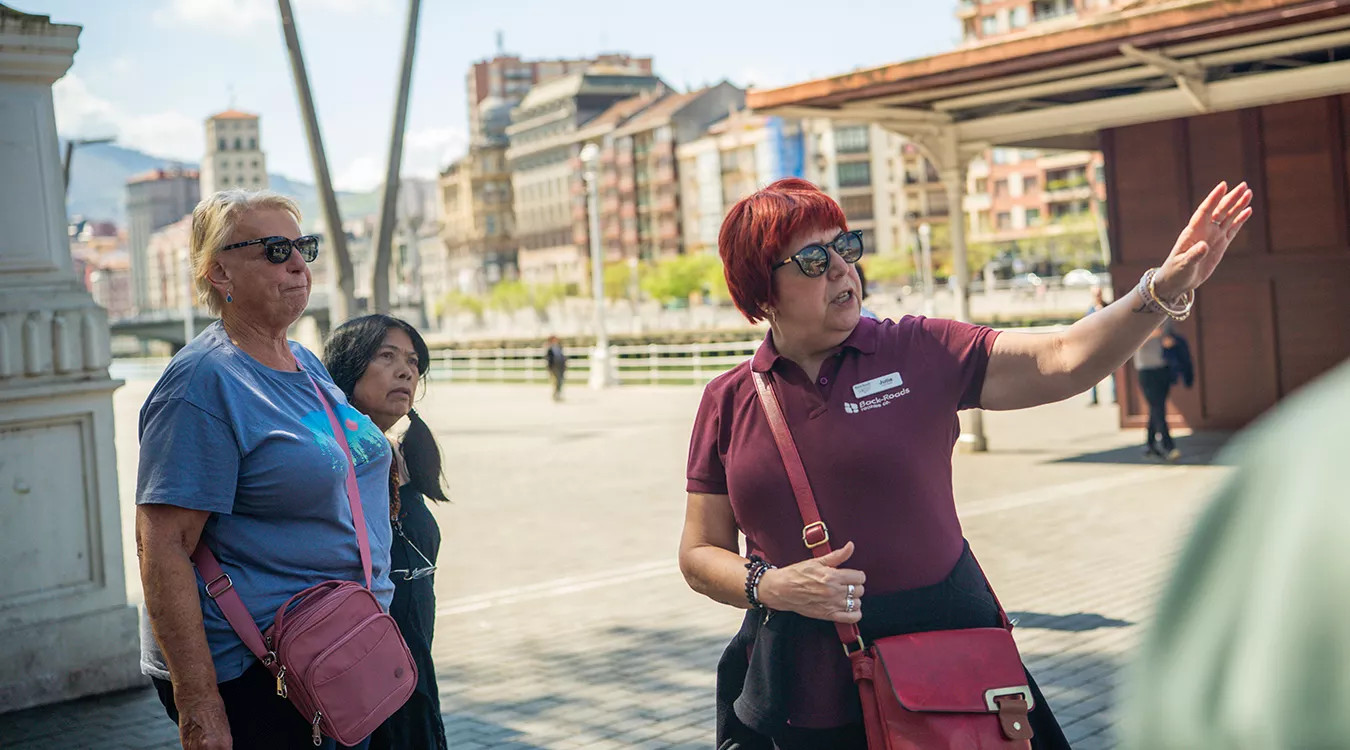 A Back-Roads tour leader speaking to two guests