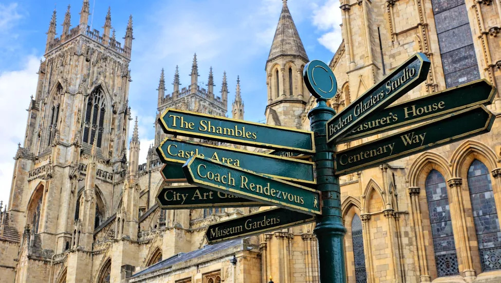A view of a signpost detailing all the York highlights, with York Cathedral in the background.