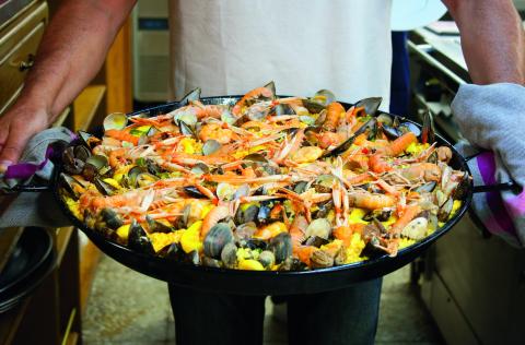 A large pan of seafood Spanish paella including prawns and mussels