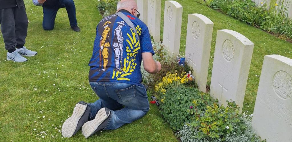 Man kneeling by war grave